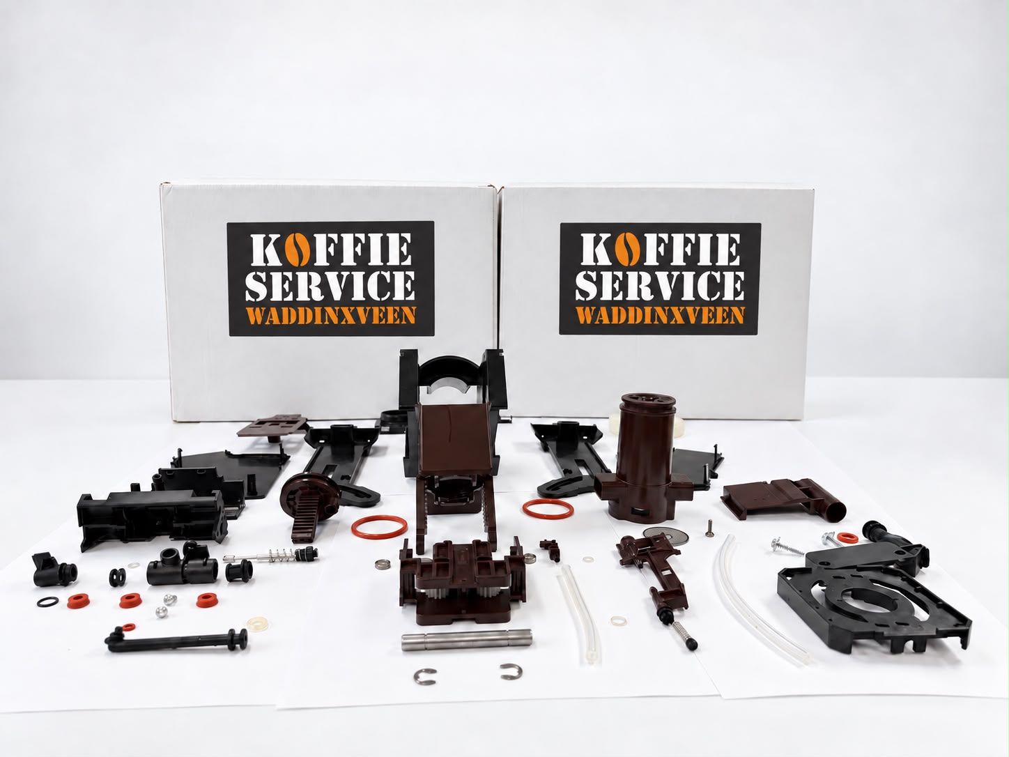 Volledig gedemonteerde koffiemachine, netjes uitgestald naast dozen van Koffie Service Waddinxveen